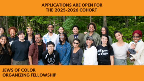 Bryant Heinzelman, the Jews of Color Organizing Fellowship Director standing with the 2023-2024 cohort of 17 fellows outside, infront of a background of trees.